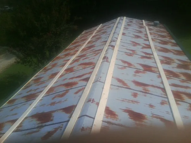 Rusted metal roof panels with new wood purlins before replacement — Storm Damage Roof Repair in Mahnomen by Roofing Brothers