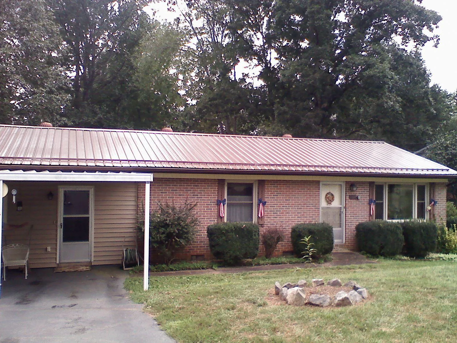 Bronze metal roof and carport on a brick ranch home — Roof Repair work by our crew in Mahnomen
