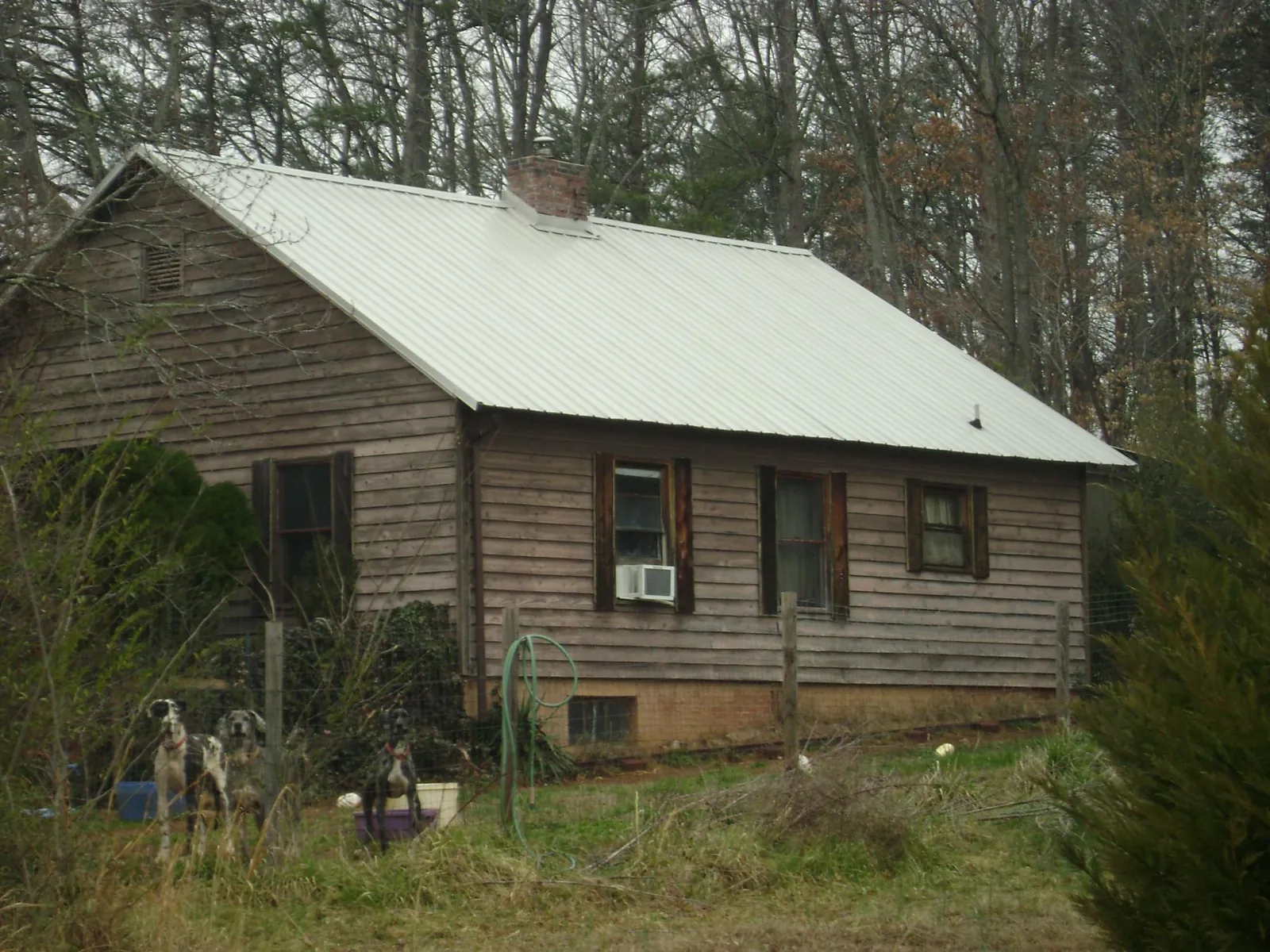 White metal roof on an old wood sided farmhouse, from a Metal Roof Installation job in Mahnomen